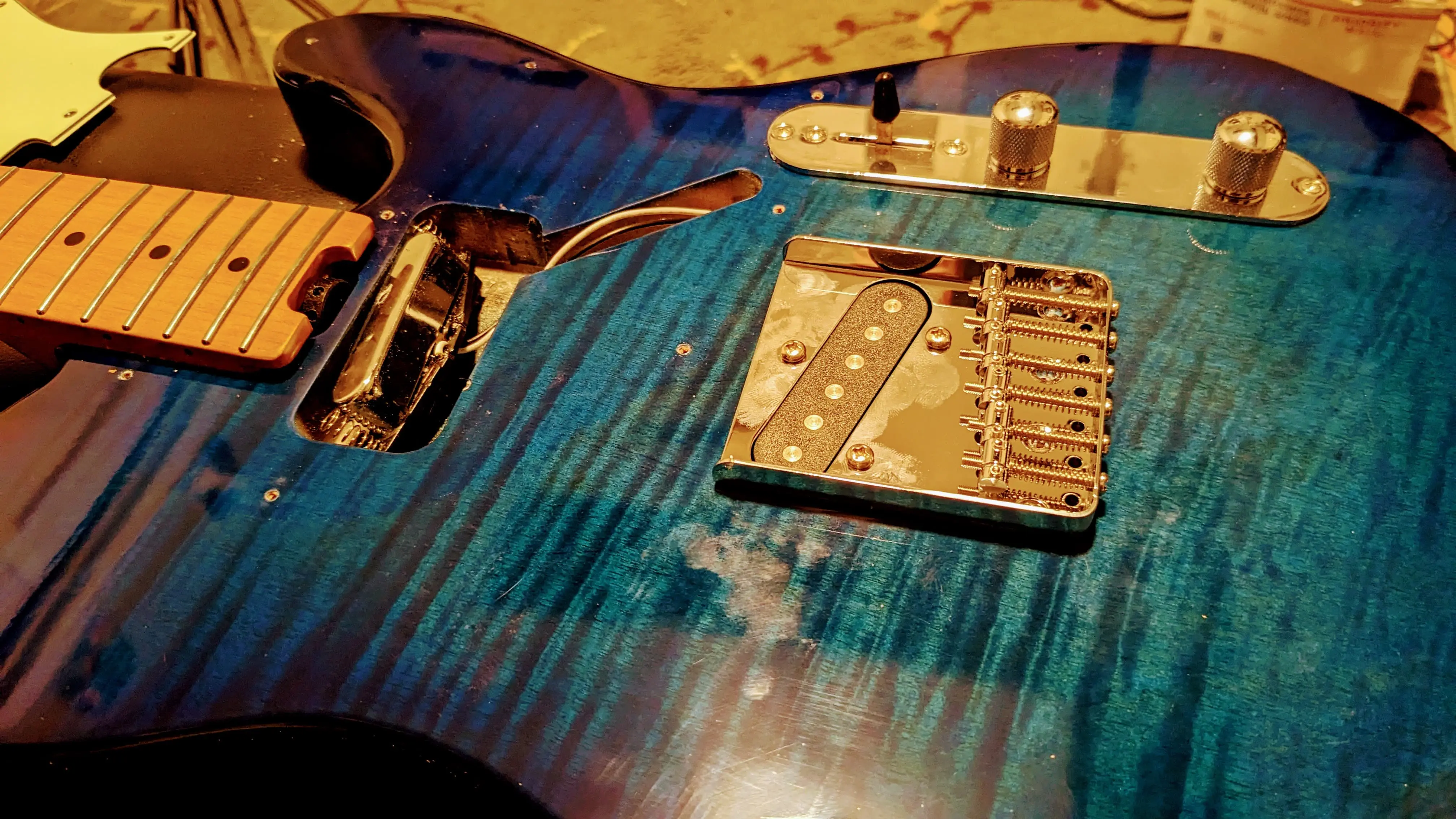 electric guitar with internals exposed on workbench